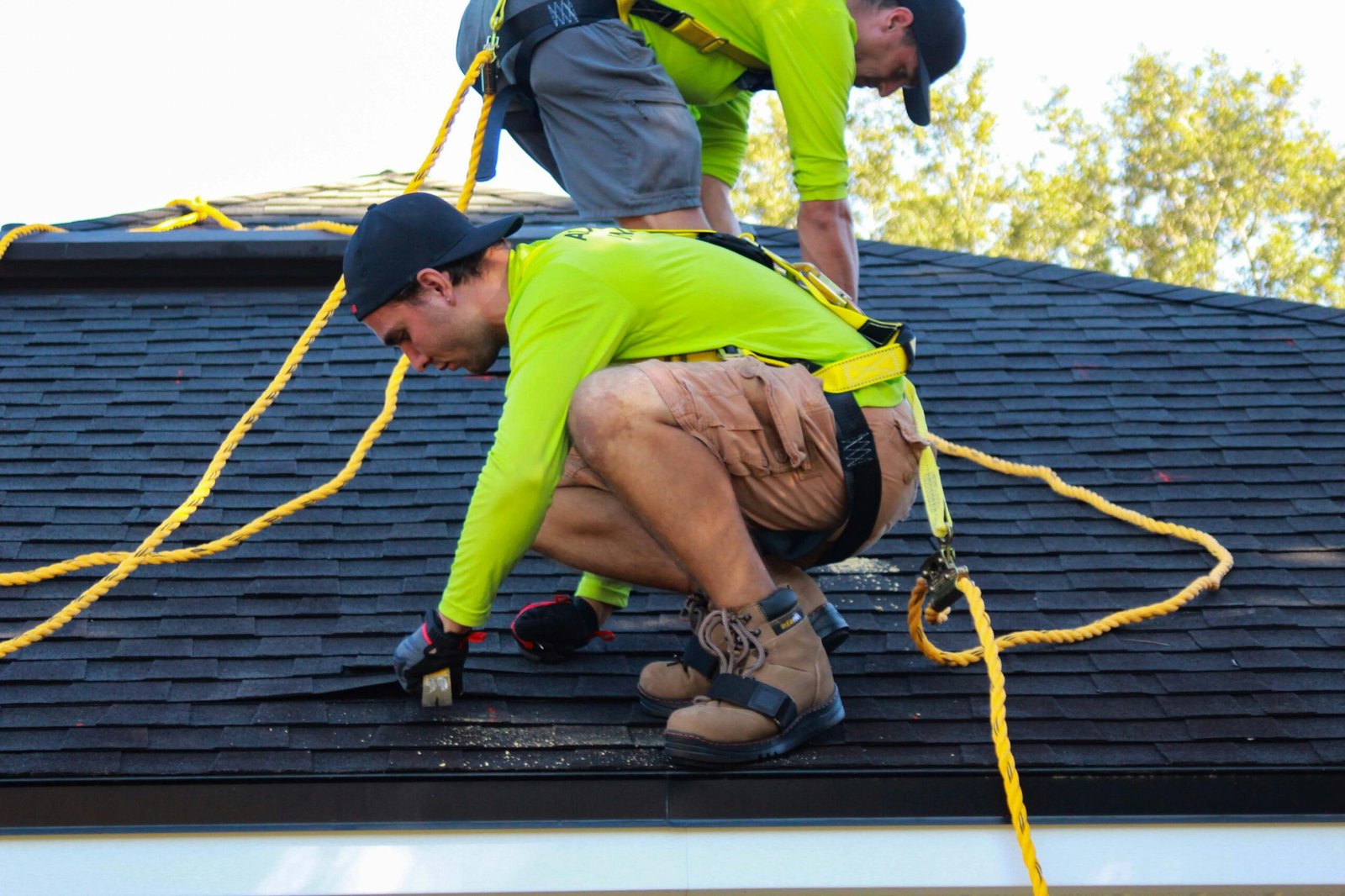 Roofer repairing an asphalt shingle roof on a Houston home